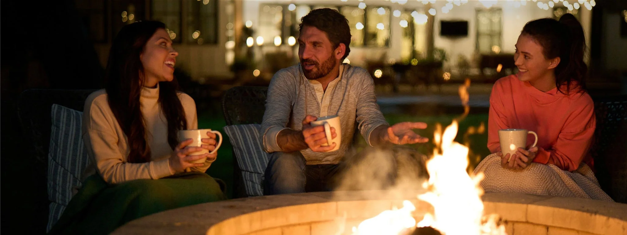 Friends gathered around a backyard firepit