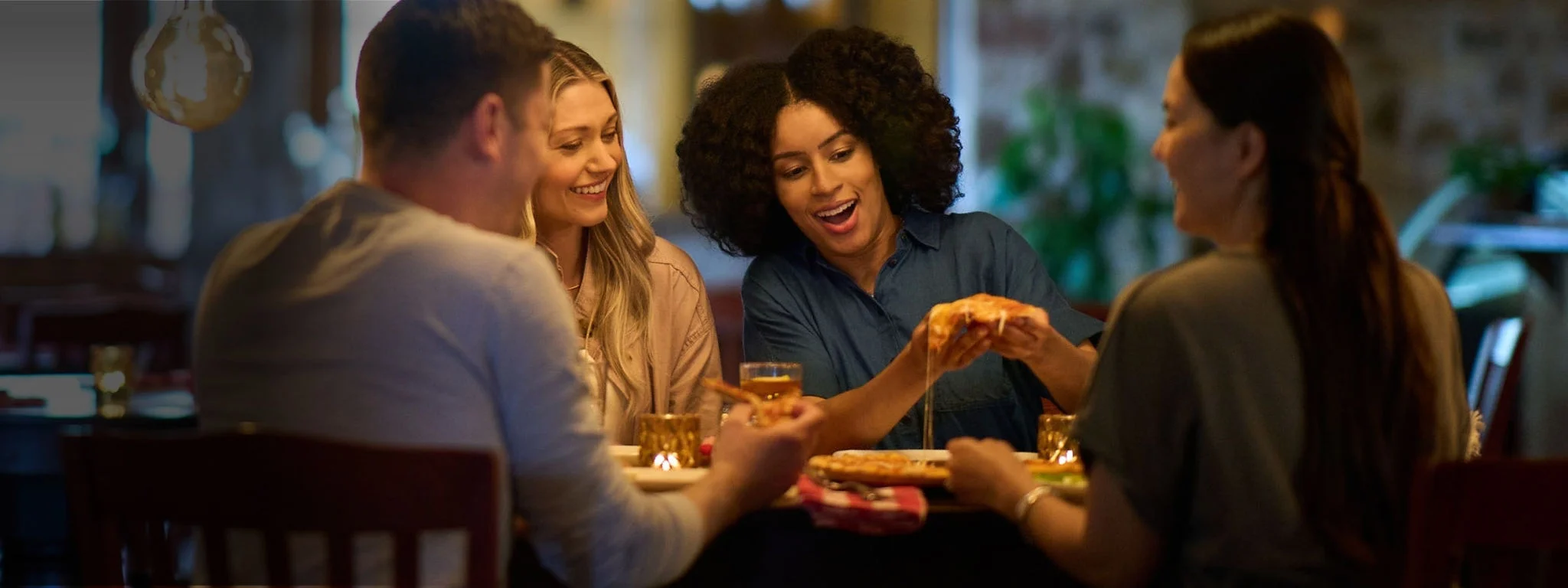 Friends at a restaurant enjoying a pizza